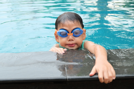 Child holding the edge of a swimming pool