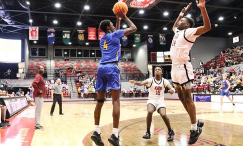 Piedmont’s Ishmael Bethel shoots as Anniston’s Hezekiah Harris (24) and Malik Bailey defend Wednesday in Pete Mathews Coliseum. (Photo by Greg Warren)