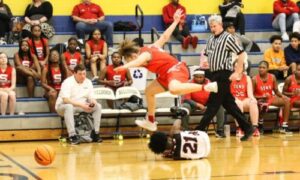 Saks’ Alonna Crews leaps over Weaver’s Aliyah Marks while going after a loose ball during their Class 3A, Area 11 tournament game at Piedmont on Tuesday.