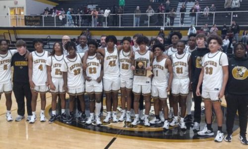 Oxford’s players and coaches celebrate their Class 6A, Area 13 title on Friday on Larry Davidson Court. (Photo by Joe Medley)