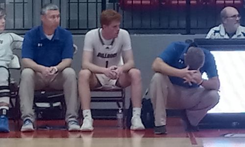 Piedmont coach Jonathan Odam bows his head as son Alex (middle) and Piedmont assistant coach Matt Glover look on in the final seconds of the Bulldogs’ loss to Plainview in the Northeast Regional on Thursday.