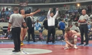 Weaver’s J.D. Johannson and Weaver coach Andy Fulmer raise arms to Weaver’s cheering section after Johannson scored the pin that clinched the Bearcats’ second state wrestling title in as many years Saturday in Huntsville’s Von Braun Center.