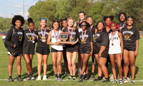 Oxford’s girls, led by Keziah Mickler (center left) and Katie Keur (center right), won their second Calhoun County track title in as many years Wednesday at Choccolocco Park. (Photo by Dana Stewart George)