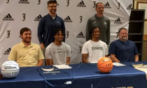 Camren Johnson (center left) and twin brother Caden Johnson pose with coaches (from left) Corey Mize, Tres Buzan Shane Morrow and Lane Patterson during Tuesday’s signing ceremony in the Jacksonville High School library. The Johnson twins will play for Shelton State Community College. (Photo by Joe Medley)