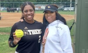 Kristin Kidd, who was born in Oxford and moved with her family at age 1, shows off her home-run ball with her mom, 2001 Oxford graduate Trachell Westbrook Kidd, after Athens’ victory over Oxford in an elimination game at Oxford Lake on Friday. (Photo by Joe Medley)