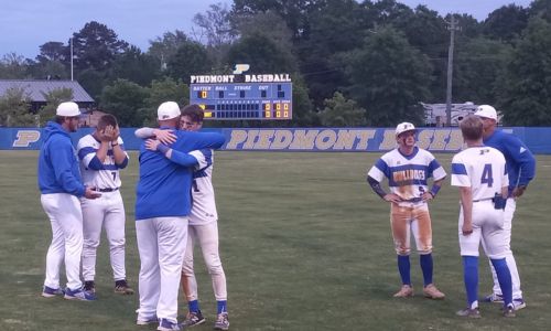 Piedmont coaches console seniors (from left) Jack Hayes, Sloan Smith, Jake Austin and Max Hanson after the Bulldogs fell to Gordo 5-3 in eight innings in Friday’s Game 3 of their Class 3A quarterfinal series at Piedmont. (Photo by Joe Medley)