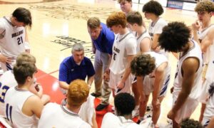 Piedmont’s Matt Glover (center) talks during a timeout at the Northeast Regional in February. He has been promoted to head coach. (Photo by Greg Warren)