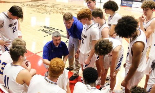 Piedmont’s Matt Glover (center) talks during a timeout at the Northeast Regional in February. He has been promoted to head coach. (Photo by Greg Warren)