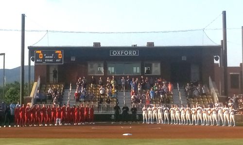 The Smash It Sports Vipers and Texas Smoke, of the Women’s Professional Fastpitch softball league, stand for the National Anthem before Friday’s Vipers’ home opener at Choccolocco Park, in their first season in Oxford. (Photo by Joe Medley)