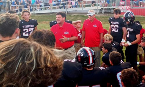 As his long-time defensive coordinator, James Blanchard, looks on, new Westbrook Christian head coach Steve Smith encourages his team before its play in Friday’s jamboree at Ohatchee. (Photo by Joe Medley)