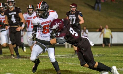 Weaver’s Damerion Welch tries to elude Donoho’s James Benkwith on Friday at Donoho. (Photo by Bo Hudgins/For East Alabama Sports Today)