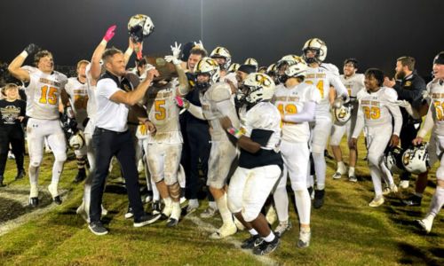 Cherokee County head coach Jacob Kelley hands the Class 4A North championship trophy to his team after the Warriors beat Westminster Christian 50-6 in Friday’s semifinal at Huntsville. (Photo by Shannon Fagan/WEIS Sports Director)