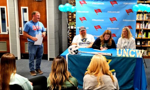 Pleasant Valley softball standout Madyson Cromer celebrates her signing with UNC-Wilmington during Thursday’s ceremony in the Pleasant Valley High library. (Photo by Joe Medley)