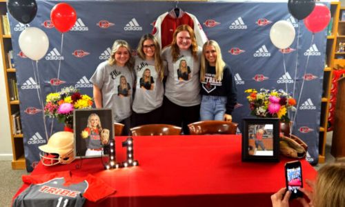 Ohatchee’s Ellie Carden (right) celebrates signing Thursday to play softball for Gadsden State Community College with friends (from left) Brylie Myer, Kiana Garber and Breanna Martin, all wearing T-shirts that spell out Carden’s nickname. (Photo by Joe Medley)