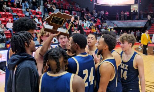 Jacksonville’s players collect their trophy after winning the 73rd annual Calhoun County tournament Friday in Pete Mathews Coliseum. (Photo by Joe Medley)