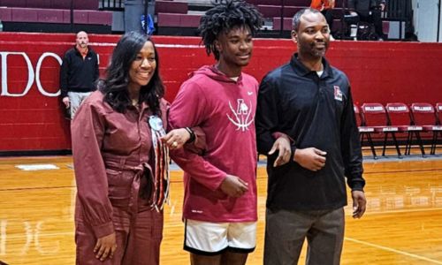 Anniston senior Kyron Brown participates in senior-night activities with his father, Anniston coach Torry Brown, and mother Deidra Brown on Monday. (Photo by Joe Medley)