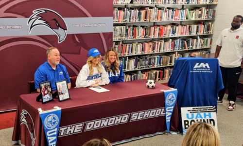 Flanked by parents Benji and Jaclyn, Donoho’s Erin Turley celebrates her signing to play soccer for the University of Alabama-Huntsville. (Photo by Joe Medley)