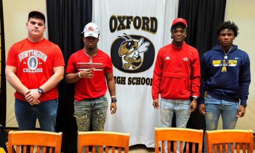 Oxford’s Andrew Kirkland (left), Jaydon Thomas, Camare Hampton and Donovan Jones pose for pictures after Oxford’s National Signing Day ceremony Wednesday. (Photo by Joe Medley)