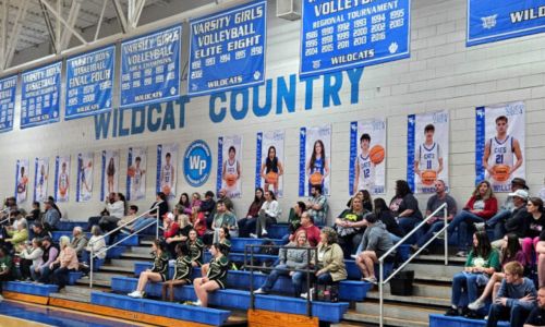 Banners honoring 13 senior basketball players line the wall behind the visiting bleachers at White Plains High School. (Photo by Joe Medley)