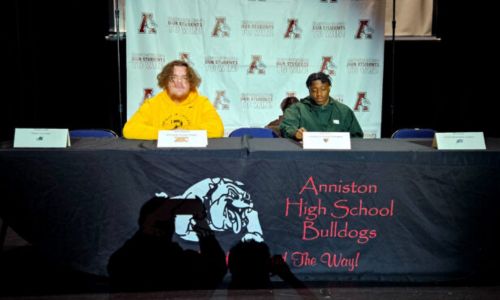 Anniston’s Collin Wansart (left) and Love Kirby participate in Wednesday’s National Signing Day ceremony in the school’s auditorium. (Photo by Joe Medley)