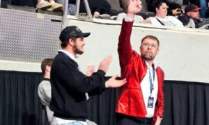 Weaver coach Andy Fulmer signals to the Bearcats’ cheering section Saturday, after they clinched their third consecutive Class 1A-4A state wrestling title in Huntsville’s Von Braun Center. (Photo by Joe Medley)