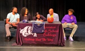 With family and Southern Union coach Earl Taylor (center right) looking on, Anniston’s A’Kayla Perry signs with the Lady Bison on Friday. (Photo by Joe Medley)