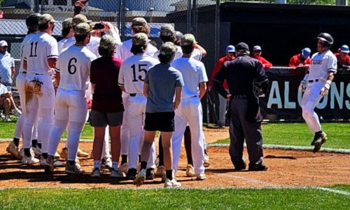 Marcus Lawler meets Donoho teammates at home plate after hitting a three-run home run in the first inning against Pleasant Valley on Saturday. The Falcons won 17-0 to clinch a playoff berth. (Photo by Joe Medley)