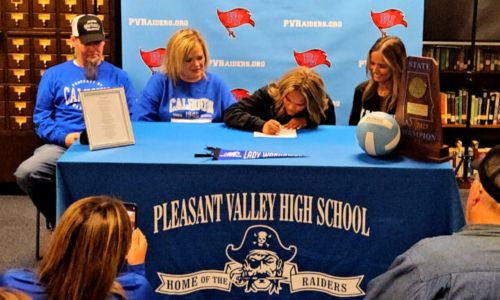 With retiring Pleasant Valley volleyball coach Dana Bryant looking on, Maddie Schwabe signs Friday to play for Calhoun Community College. (Photo Joe Medley)