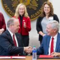 Jacksonville State University President Dr. Don C. Killingsworth, Jr., left, and Regional Medical Center President and CEO Louis Bass, right, shake hands after signing a memorandum of understanding that allows eligible RMC employees to receive a 20% tuition scholarship for continuing their education. (JSU Photo)
