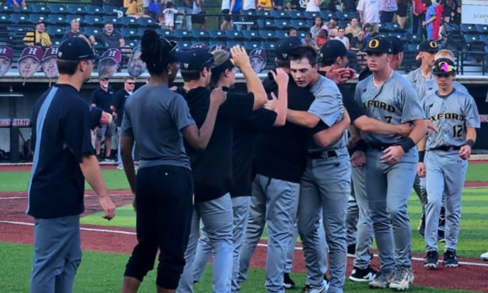 Oxford players embrace after the Yellow Jackets fell to Hartselle 4-1 in Game 3 of their Class 6A state final series Thursday on Rudy Abbott Field. (Photo by Joe Medley)