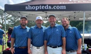 Local golf enthusiasts (from left) Aaron Gregerson, Matt Miller, Ted Gregerson and Jeremy McGatha pose in front of the Ted’s Floors & Beyond tent near the No. 16 tee at Anniston Country Club. The first annual Ted’s Charity Invitational Golf Tournament tees off Saturday at Anniston Country Club. (Submitted photo)