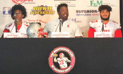 Saks coach Alphonso Freeney, flanked by seniors Jacori Avery and Mason Stevens, talks during Calhoun County Quarterback Club Media Day in July. (Photo by Joe Medley)