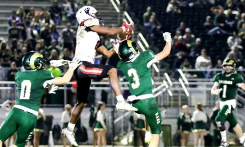 Weaver’s KeShawn Allen goes up for a catch between two Sylvania defenders during their first-round playoff game at Sylvania on Friday. (Photo by Greg Warren/For East Alabama Sports Today)