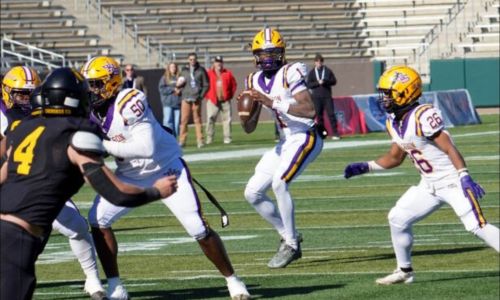 Jackson quarterback Landon Duckworth sets to throw as lineman Steven Taite (50) and back Gavin Jackson (26) block up front (Photo by David Holtsford/AHSAA)