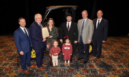 Whit and Amanda Lovelady of Talladega County received a prize package worth more than $70,000 as Alabama’s 2024 Outstanding Young Farm Family (OYFF) contest winner. The Loveladys were honored during the Alabama Farmers Federation’s 103rd annual meeting in Montgomery Dec. 9. From left are Federation Young Farmers Division Director Hunter McBrayer; Federation and Alfa President Jimmy Parnell; the Loveladys; Alabama Ag Credit’s Doug Thiessen; and Alabama Farm Credit’s Mel Koller.