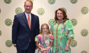 Millie Henderson of Calhoun County was honored for earning sixth place in the Alabama Farm-City Fourth-Sixth Grade Poster Contest April 17 during an annual awards luncheon in Auburn. Henderson is a student at Ohatchee Elementary School. They received $25 from Alabama Ag in the Classroom (AITC) for their poster, which showcased the theme of “Our Community Counts on Farmers.” From left are Alabama Farm-City Committee Chair Jeff Helms, Henderson and Alabama AITC Steering Committee Chair Kim Earwood.