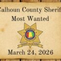 Wanted poster with sheriffs star attached to wood planks