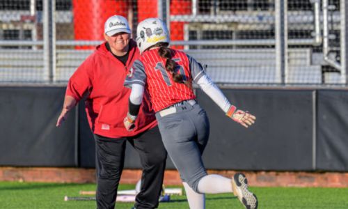 Kendall Poe, seen congratulating Madison Mize after Mize homered against Gloencoe on March 12, will add varsity girls’ basketball to her coaching responsibilities. (Photo by Brad Campbell/sport-shutter.com)