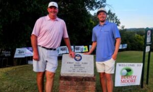 Gary Wigington (left) and Jacob LeCroy pose by the stone honoring Buddy Moore on Sunday, after winning the 18th Buddy Moore Charity Golf Tournament at Anniston Municipal Golf Course. (Photo by Joe Medley/East Alabama Sports Today)