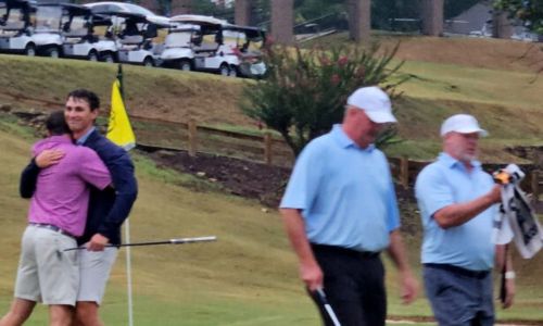 Harrison Hughston grins as teammate Jacob LeCroy hugs him Sunday after the duo won their second consecutive Sunny King Charity Classic title at Anniston Country Club. (Photo by Joe Medley/East Alabama Sports Today)